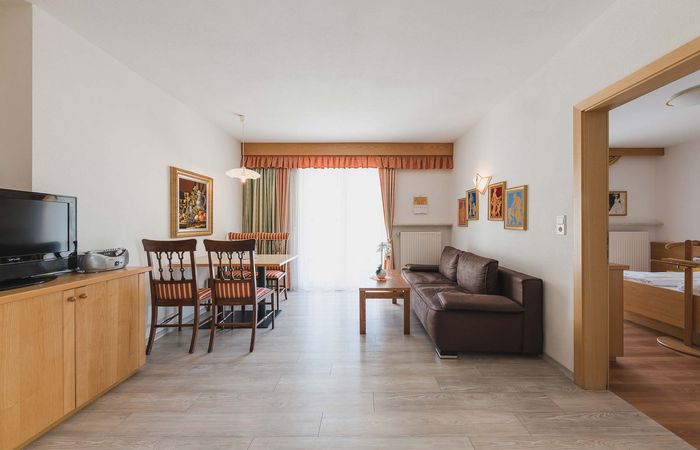 Dorf Tirol Appartement Wohnzimmer Wohnraum Couch Esstisch TV Harmony